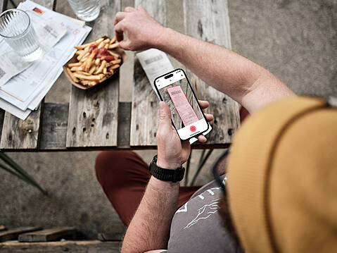 Bild von Lexware: Person fotografiert mit dem Smartphone via Lexware App einen Beleg