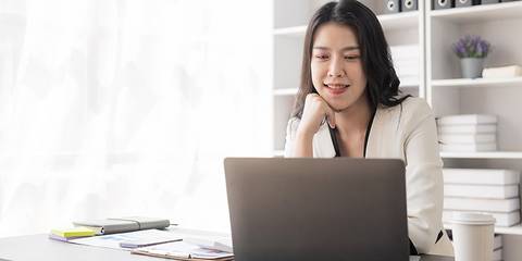 Eine Frau sitzt vor einem Laptop in einem Büro