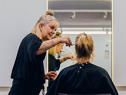 Friseurin Steffi Sch&amp;ouml;ne schneidet einer Kundin in ihrem Salon die Haare
